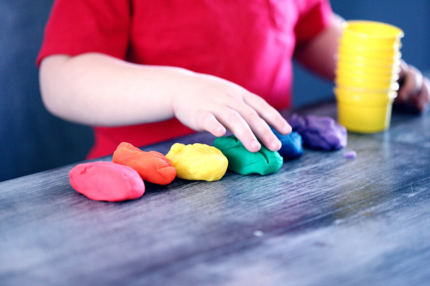 closeup of child playing with playdough